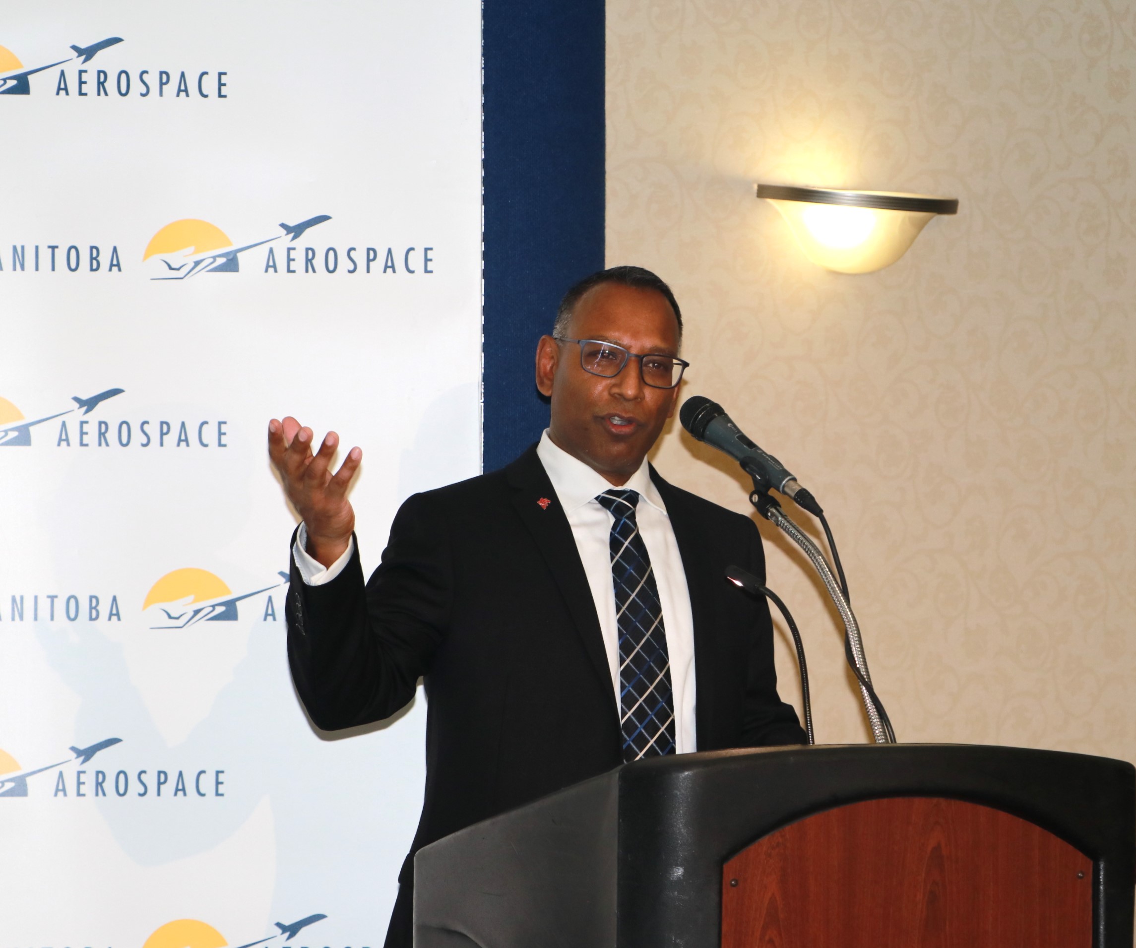 RRC Polytech graduate Ron Drepaul speaks at a podium at the Manitoba Aerospace All-Star Awards dinner. 