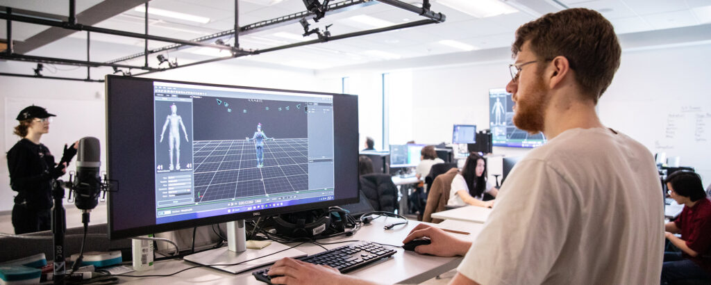 Students in a motion capture studio capturing the movement of a student in a motion capture suit