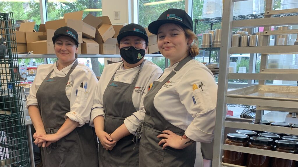 three people standing in a kitchen