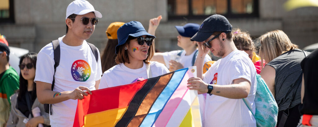 People holding a pride flag at a parade