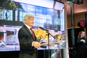 Walter Schroeder speaks at podium, at event announcing RRC Polytech as the home of the Schroeder Institute of Entertainment and Media Arts.