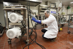 Man demonstrating how to use equipment in a kitchen