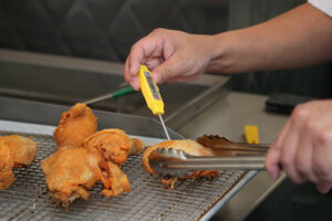 Chef using a thermometer to check the temperature of meat