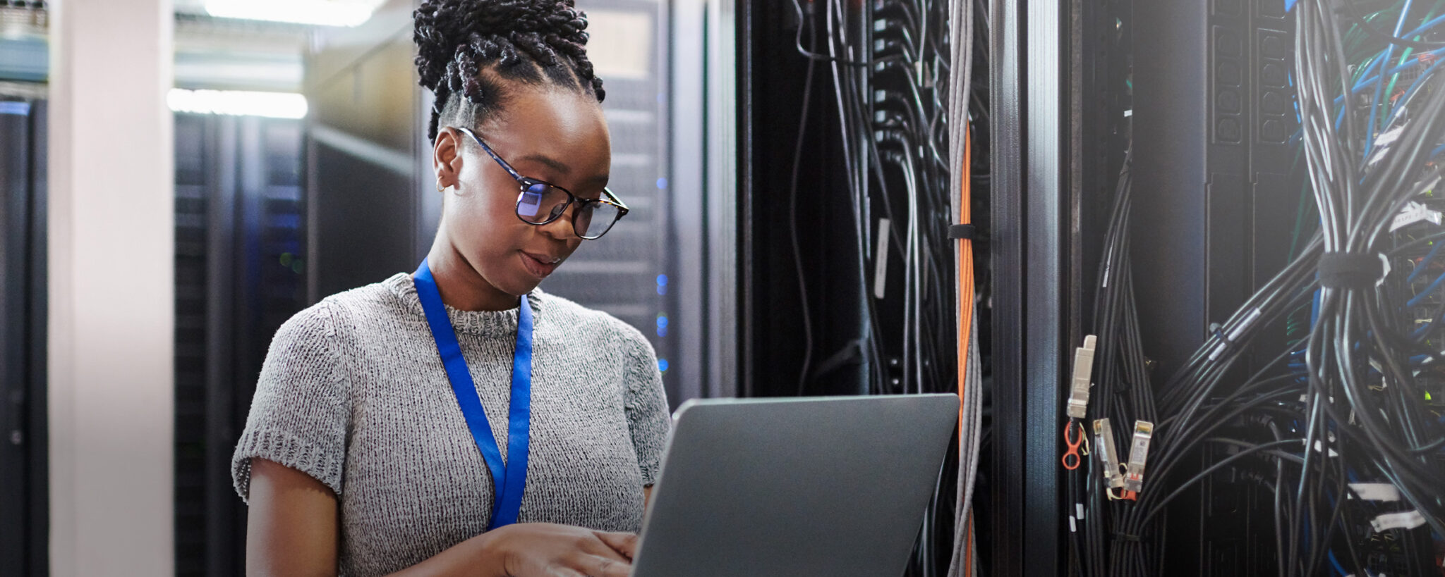 Woman in a data centre using a laptop