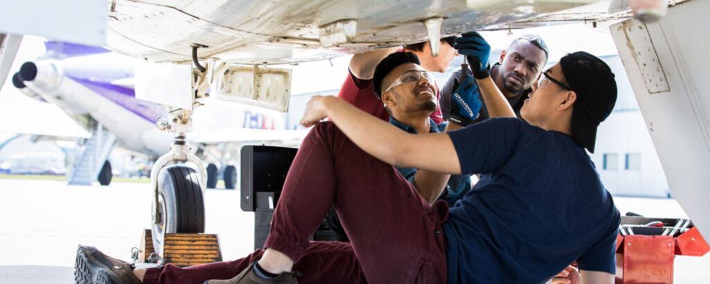 Students working on aircraft in a hangar