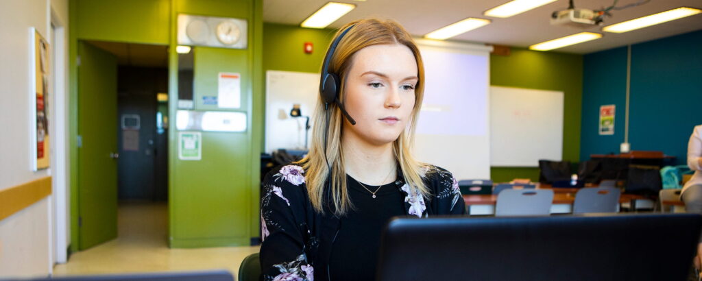 Woman wearing headset looking at computer screen