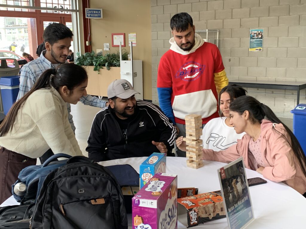 Group of students around a table playing jenga.