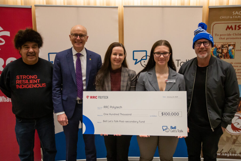 RRC Polytech members holding a giant cheque from Bell Canada. 