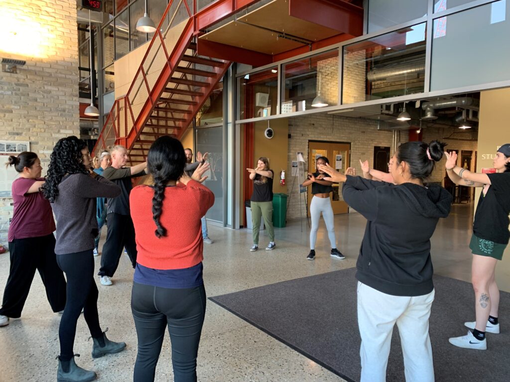 Group of students in circle learning self defense.