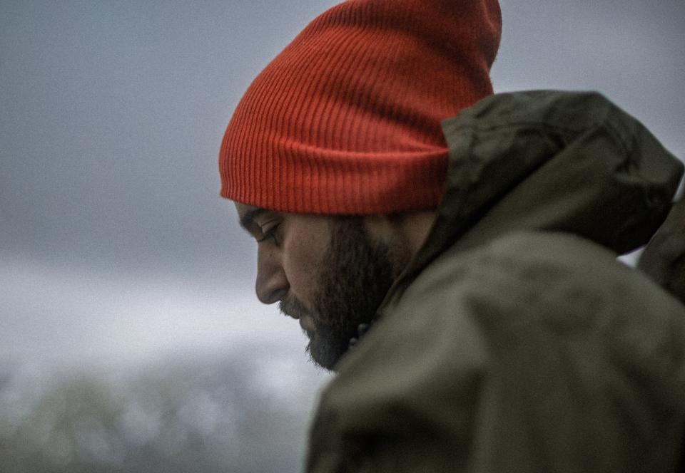 Man sitting outside in the cold winter looking down.