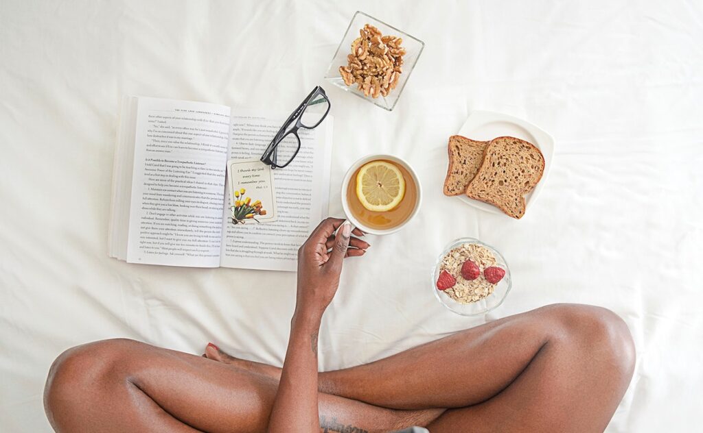 Woman having breakfast in bed - top view 