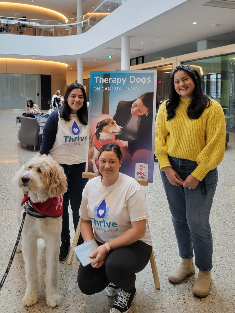 Three women at a therapy dog visit at EDC