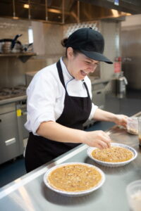 Anna Borys smiling and working in a kitchen