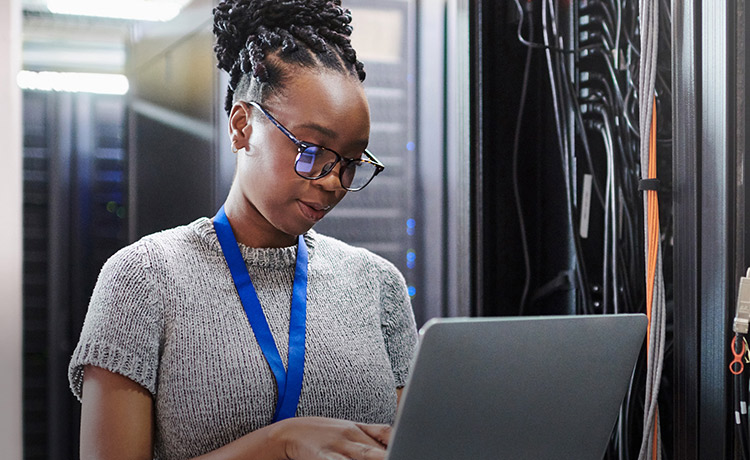 Woman in a data centre using a laptop