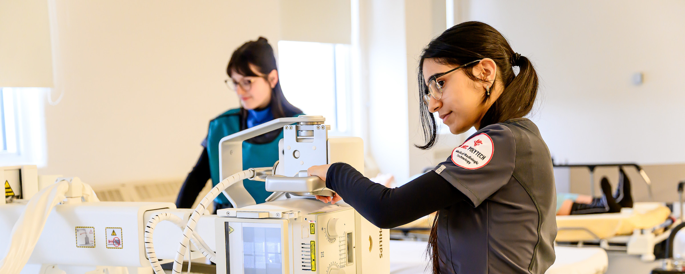 Radiologic technology student learning to operate the equipment in a lab