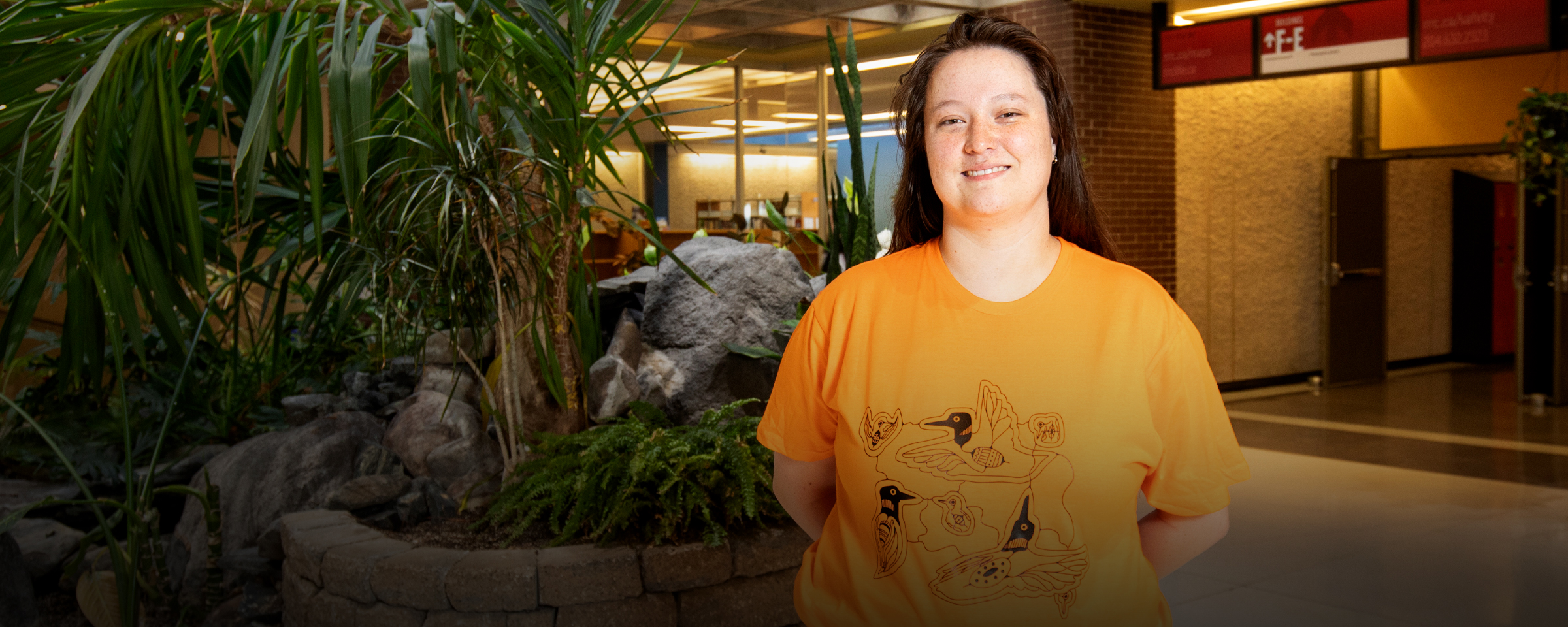 Portrait of RRC Polytech alum Erin Ringland, wearing the shirt she designed for Orange Shirt Day 2024.