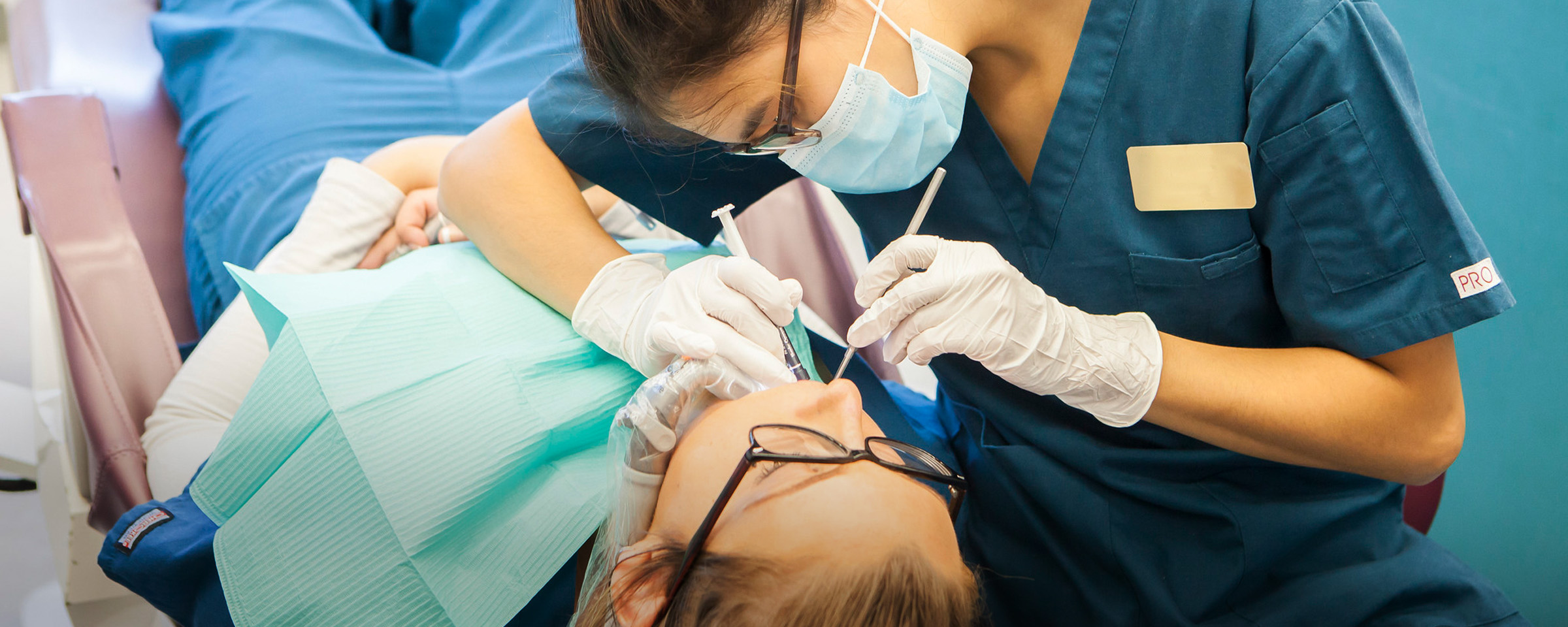 Dental Assisting student cleaning a patient's teeth.