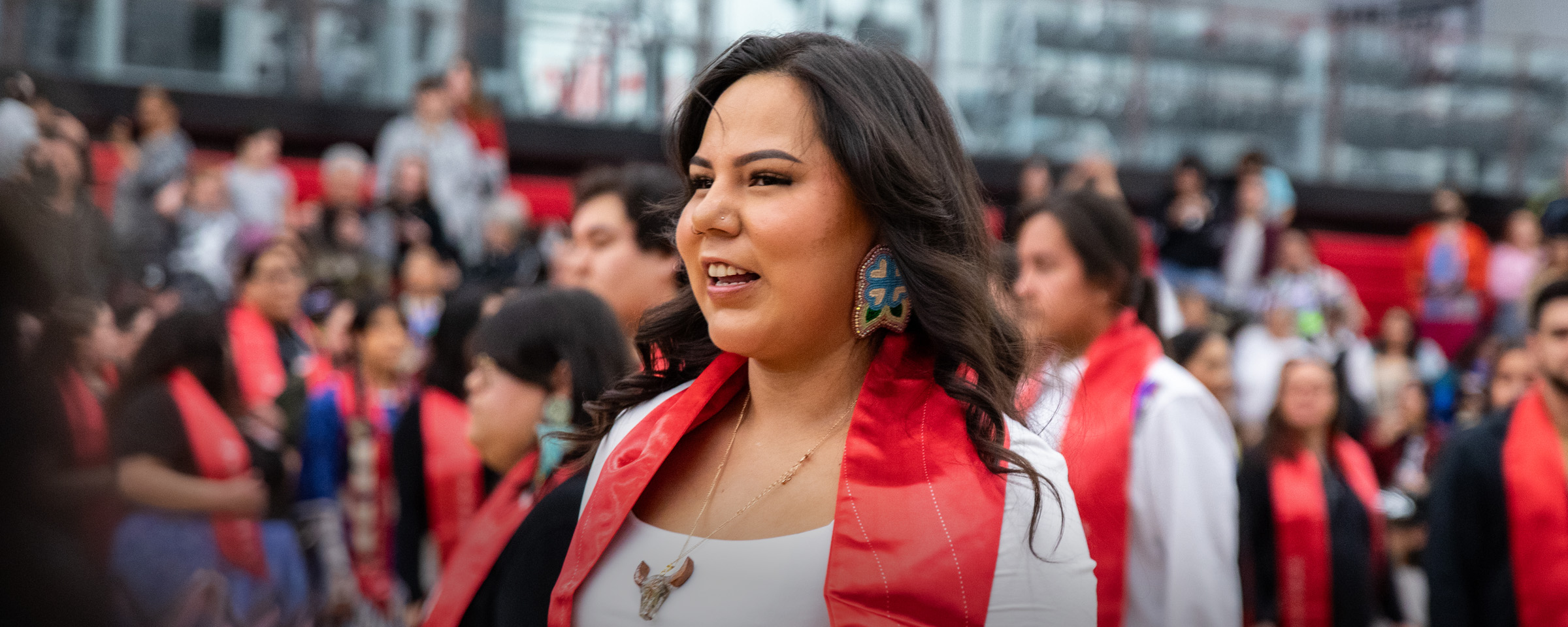 Student wearing Indigenous stole attending RRC Polytech's graduation pow wow.