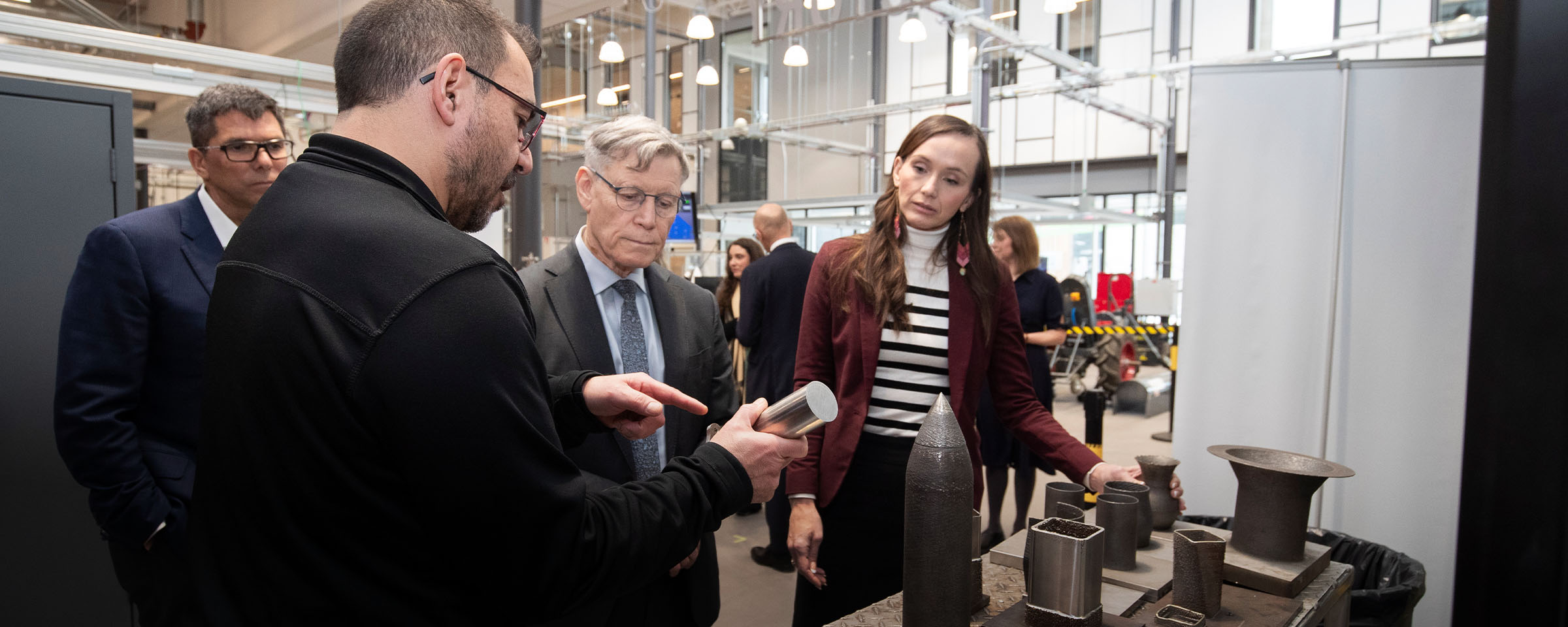 Visitors inspecting metal samples made in RRC Polytech's manufacturing lab.